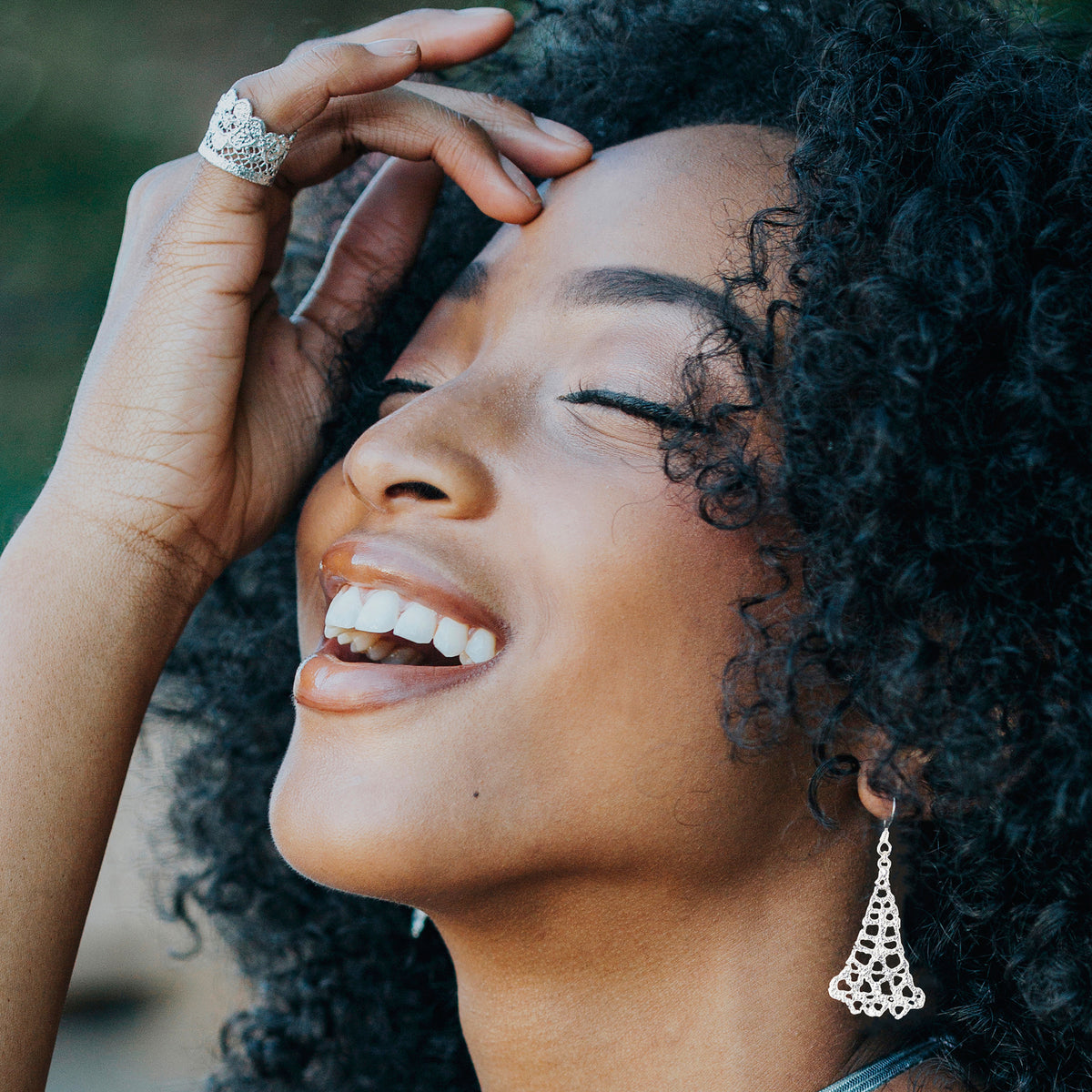 Model wearing silver teardrop earrings made from 1940s Swedish bobbin lace dipped in sterling silver.