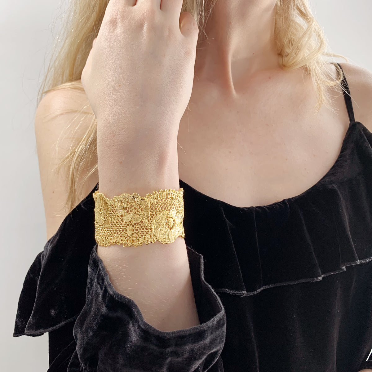 Donna lace cuff bracelet in 24k gold on a model.