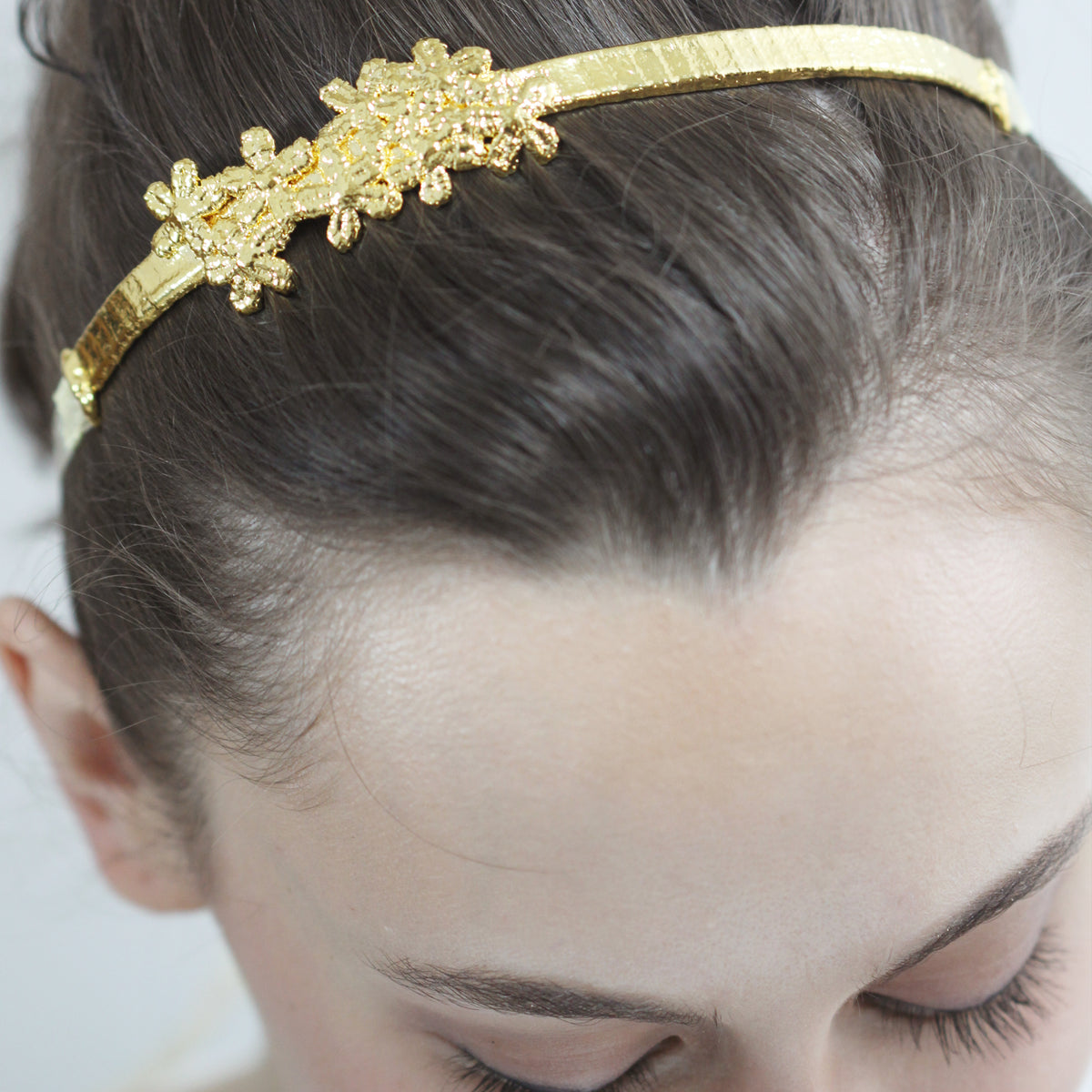 Flower lace hairband in 24k gold on model.