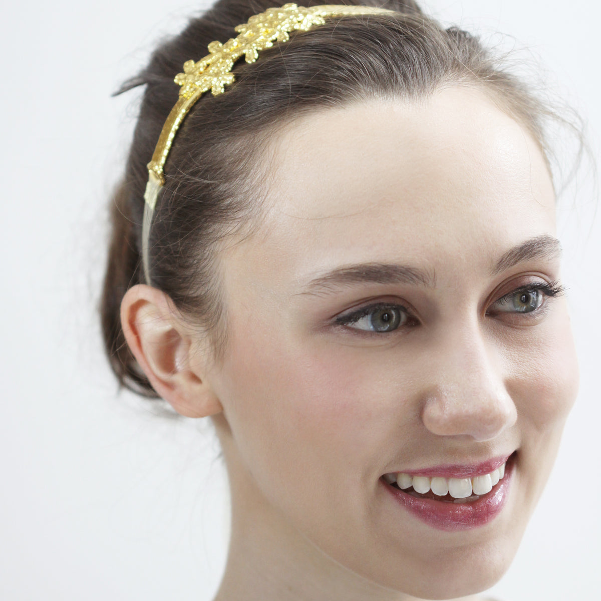 Flower lace hairband in 24k gold on a model.