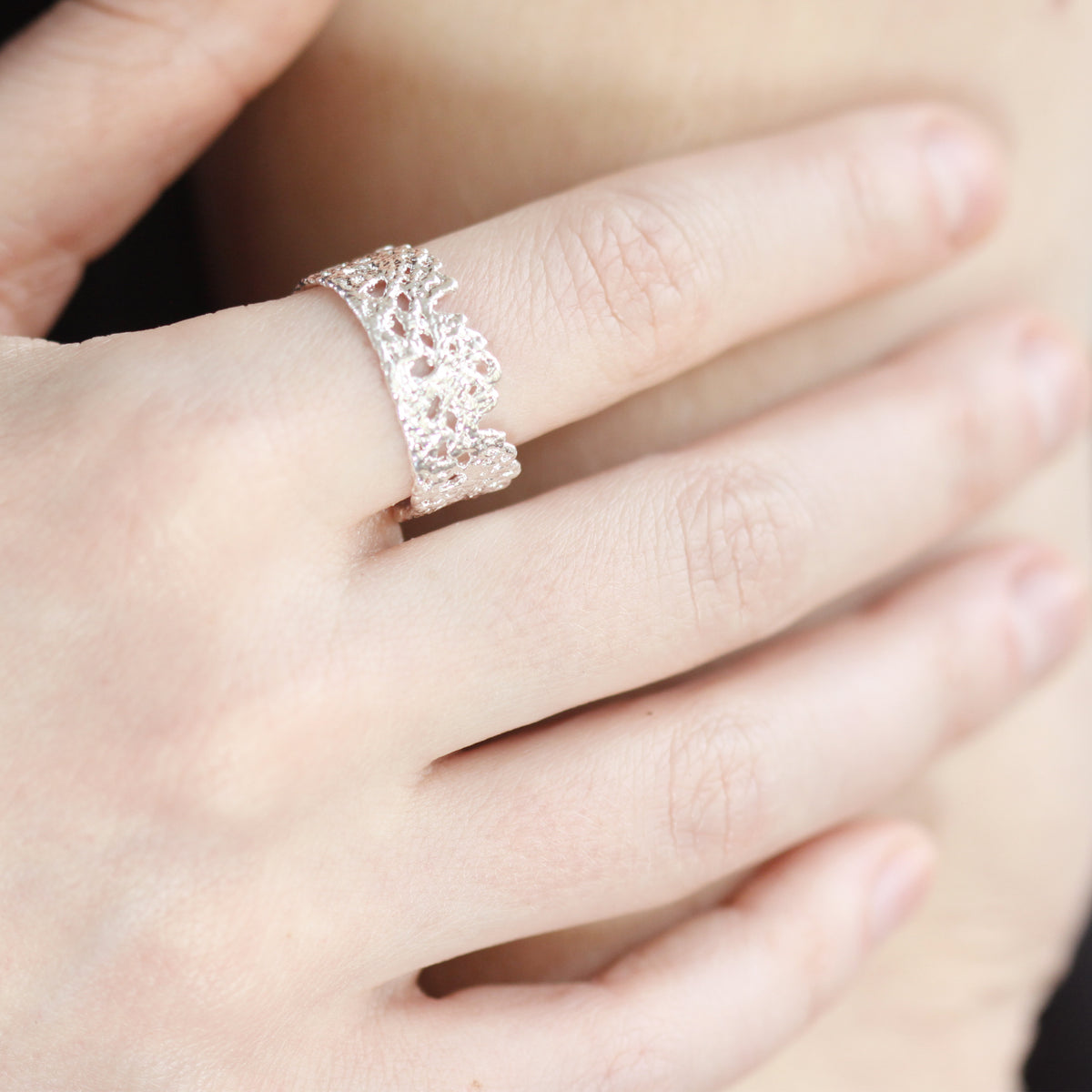Model wearing lace crown ring in sterling silver with real lace inside.