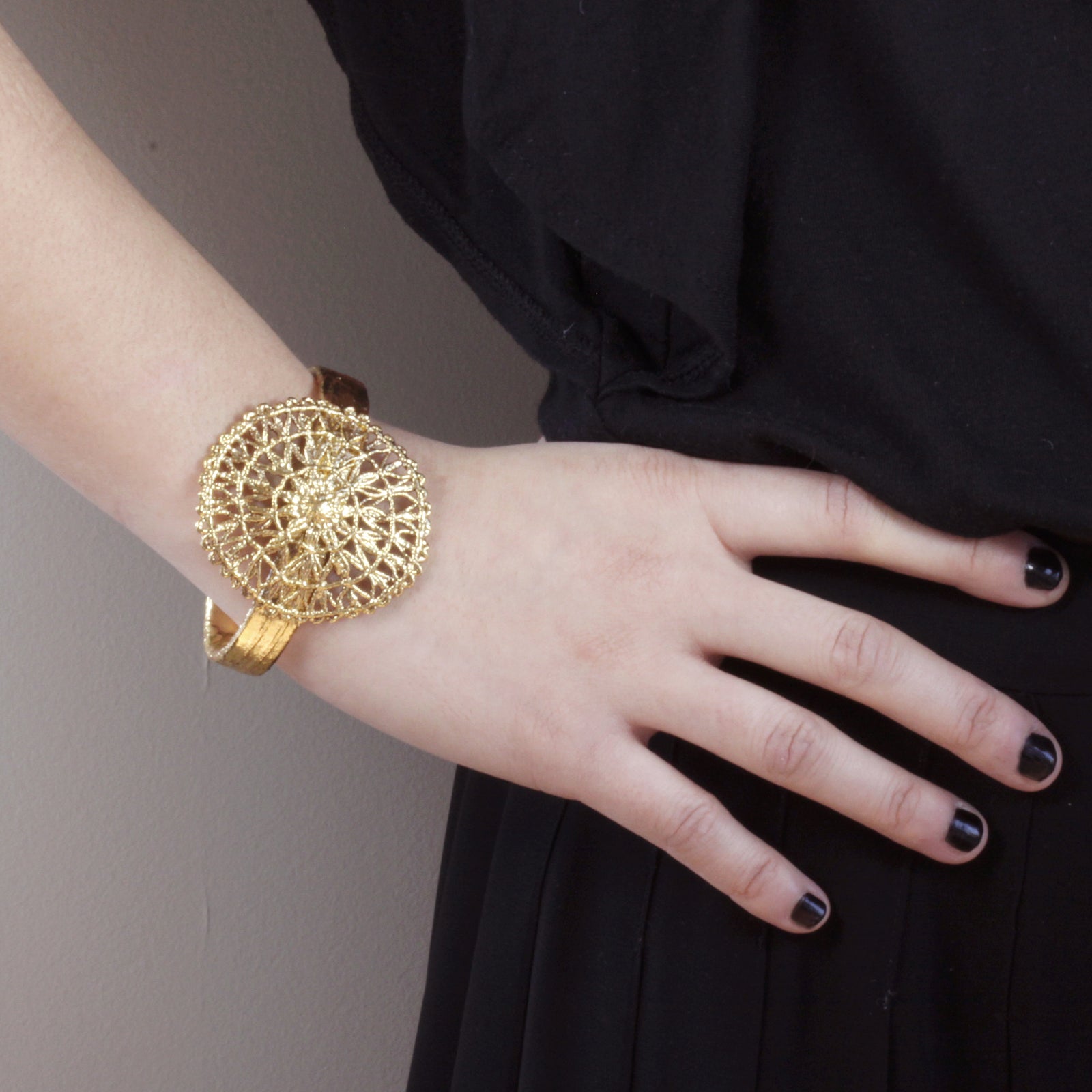 The 24k gold dipped Rebecka bangle bracelet with a large round Tenerife lace centerpiece.