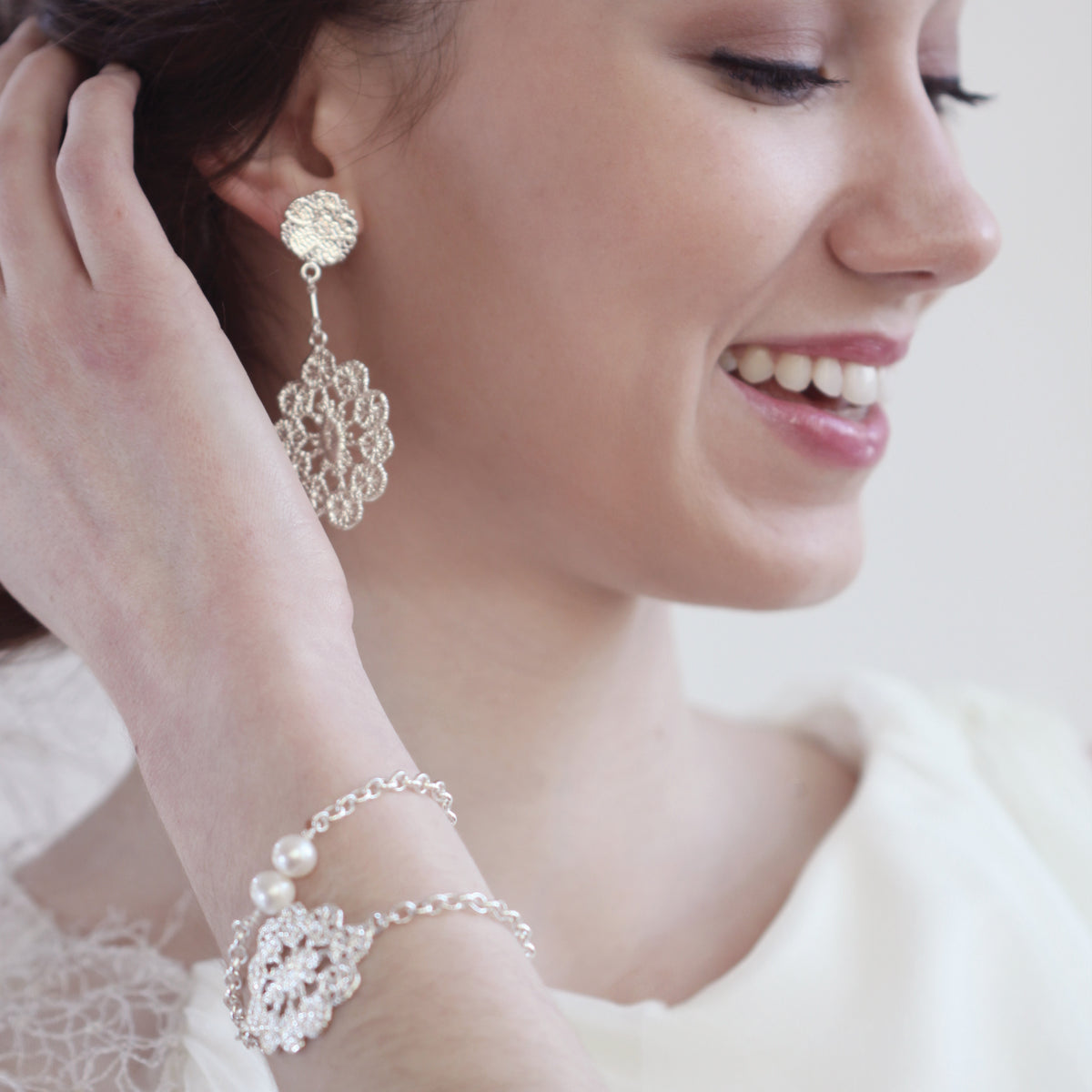 Exquisite chain bracelet with lace medaillon in sterling silver and two white pearls on model.