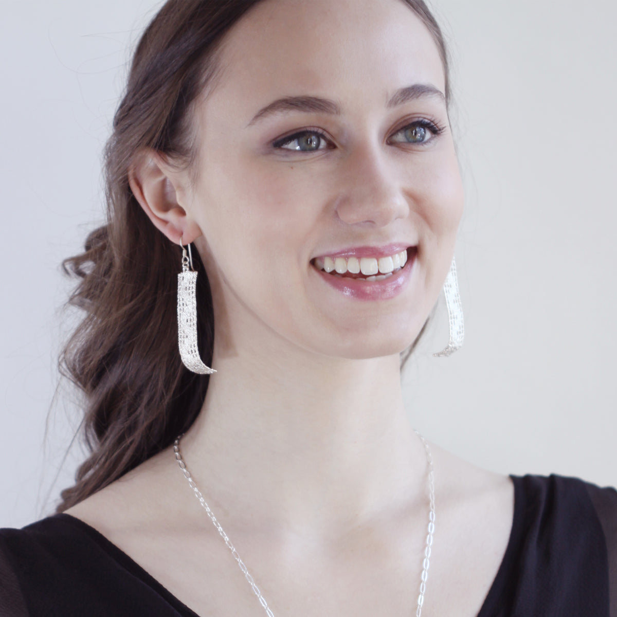 Long lace earring in sterling silver on a French wire worn by a model.